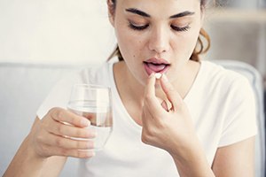 Young woman taking oral conscious dental sedation pill